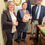 La Delegata Roberta Ceppatelli e il Simposiarca Max Ferranti consegnano il volume dell'Accademia alla cuoca Francesca Golino